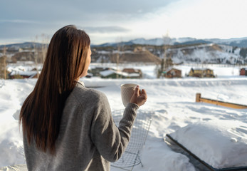 Fototapeta na wymiar Woman drinking hot beverage in mountains during winter