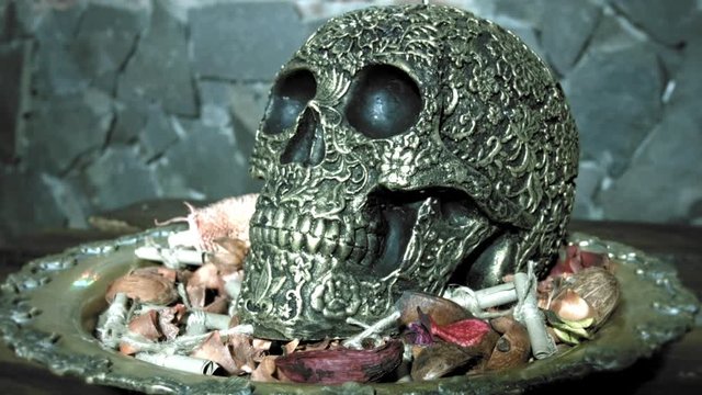 Golden human skull on a dish