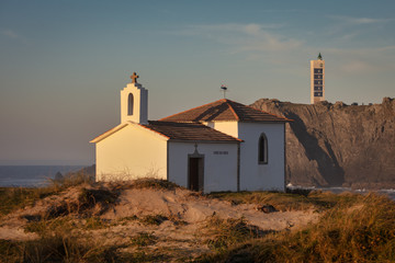 Fototapeta na wymiar Ermita da Virxe do Porto y Faro de Punta Frouxeira en Valdoviño, Galicia.