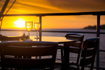 Wine glasses on balcony overlooking at sunset