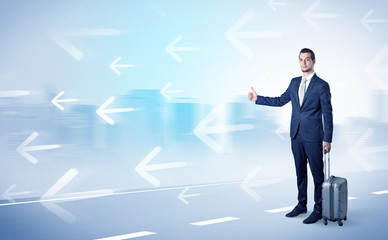 Young businessman hitchhiking near the city with arrows around concept