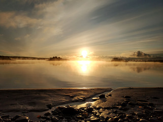 Autumn sunrise in the fog on the lake Yanisyarvi in Karelia
