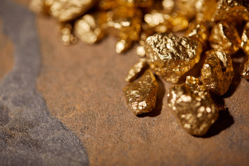 selective focus of golden stones on brown marble background
