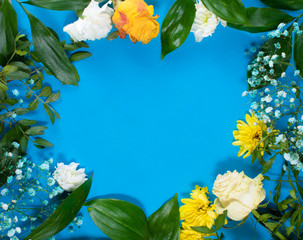 Round frame made of yellow and white summer flowers with green leaves. Valentine's background