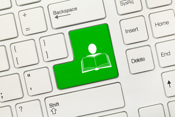 White conceptual keyboard - Green key with man and book symbol