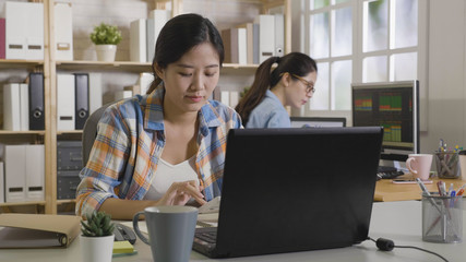 Female business analyst counting corporate profit company income analysis using calculator sitting at workplace desk. Office daily routine work in process. woman colleague concentrated working on pc