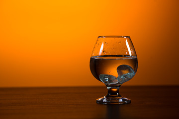 glass with alcohol on a yellow background