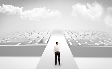 Businessman going straight ahead on a wide road between mazes
