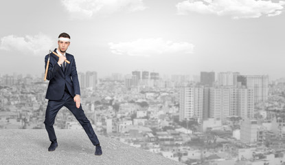 Young suited karate trainer doing karate tricks on the top of a metropolitan city
