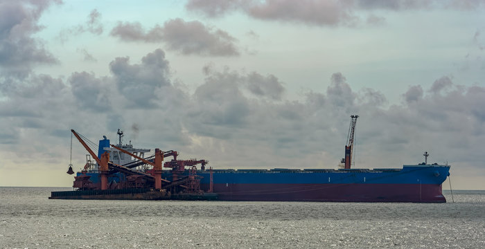 Loading Ocean-going Bulk Carrier Ship With Bauxite Aluminum Ore From The Mini Bulk Carrier (feeder) Vessel At Offshore Kamsar Port, Guinea, West Africa.