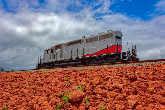 Freight diesel locomotive parked on train tracks at the end of the railway line built for bauxite ore transshipment. Guinea, Africa.