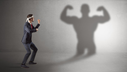 Businessman fighting with his bossy yelling shadow
