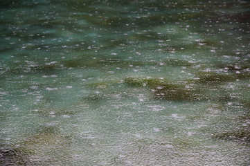 raindrops on the water surface of a deep blue lake