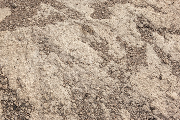 Warm textured concrete wall with small stones as an abstract background