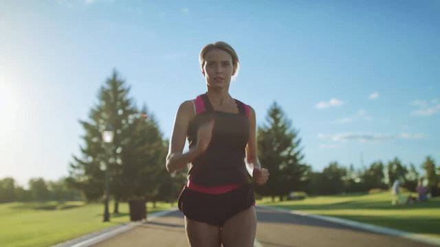 Woman runner running in slow motion. Sport woman running on park road