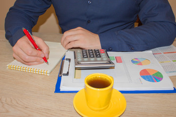 Man pointing writing goals on a paper,writing business plan at workplace, man holding pens, papers, notes in documents, Saving money concept