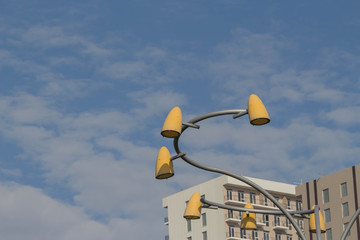 Electric light illumination in a town. Street lamp against sky and building background