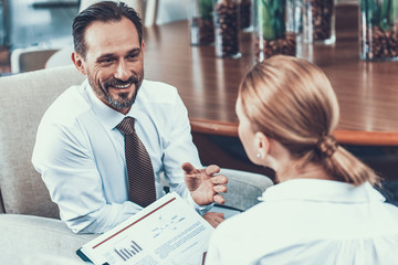 Excited businessman smiling while talking to colleague