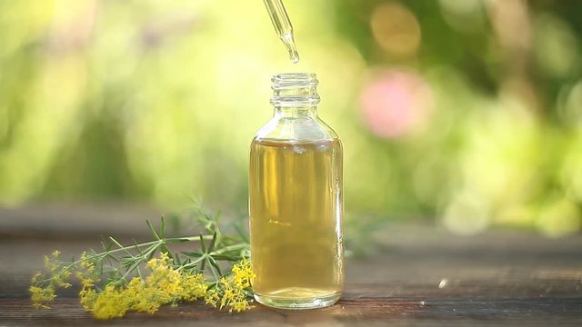 yellow bedstraw essential oil in  beautiful bottle on table