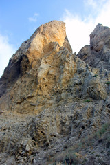 beautiful big high relief rocky stone cliff of sandy color on  blue sky background in crimea