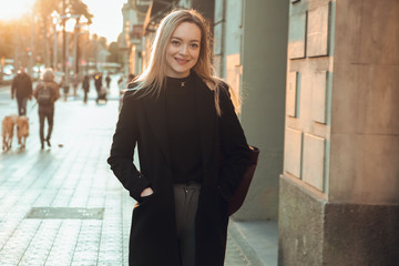 Obraz premium Portrait of blond and smiling girl dressed in black at sunset in Barcelona