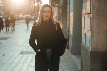 Obraz premium Portrait of blond and smiling girl dressed in black at sunset in Barcelona