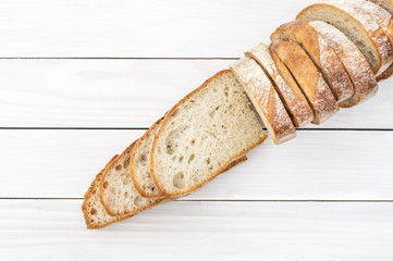 Row of cutted pieces of bread on white wooden table. Top view.