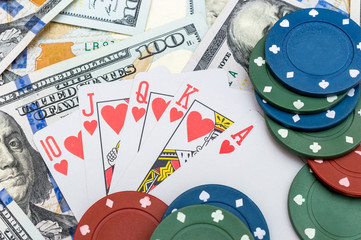 Poker chips and playing card on background of dollar bills.