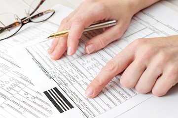 Woman filling health insurance claim form. Close up.