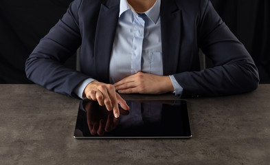 Business woman working on  tablet with dark background and copyspace
