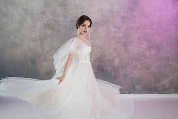 Beautiful and stylish bride in wedding dress with a lush flying skirt in