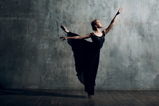 Ballerina female. Young beautiful woman ballet dancer, dressed in professional outfit, pointe shoes and black dress.