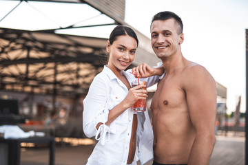 Waist up of attractive couple smiling to the camera outdoors