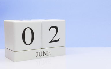 June 02st. Day 2 of month, daily calendar on white table with reflection, with light blue background. Summer time, empty space for text