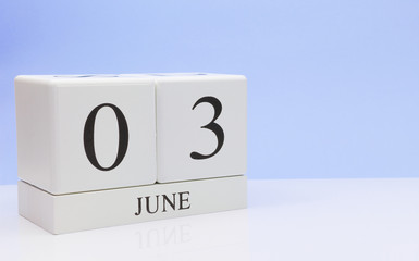 June 03st. Day 3 of month, daily calendar on white table with reflection, with light blue background. Summer time, empty space for text