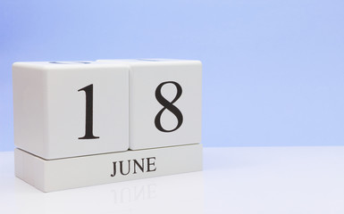 June 18st. Day 18 of month, daily calendar on white table with reflection, with light blue background. Summer time, empty space for text