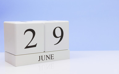 June 29st. Day 29 of month, daily calendar on white table with reflection, with light blue background. Summer time, empty space for text