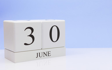 June 30st. Day 30 of month, daily calendar on white table with reflection, with light blue background. Summer time, empty space for text