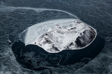 Iceland island in frozen lake aerial