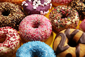 assorted donuts with chocolate frosted, pink glazed and sprinkles donuts