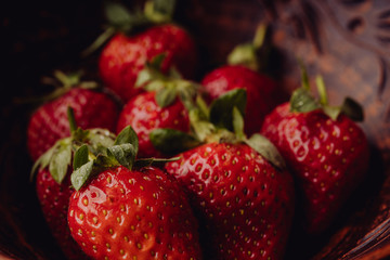 Fresh strawberries in a clay plate. Fresh berries on the table. Red strawberries in a brown bowl. Fruit close-up