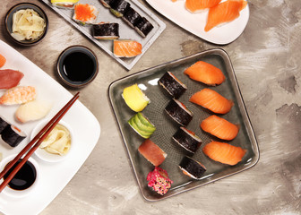 close up of sashimi sushi set with chopsticks and soy - sushi roll with salmon and sushi roll with...