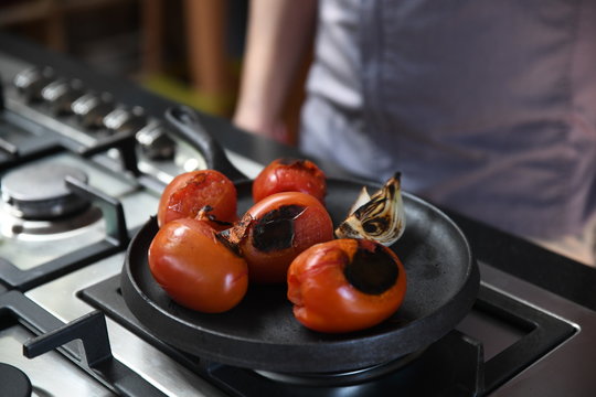 Charred tomatoes and garlic on a griddle