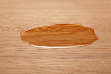 A drop of oil on a wooden surface. Selective focus.