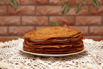 Pancakes on the white plate. Many pancakes are stacked.