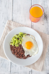 Portion of red quinoa with fried egg and celery
