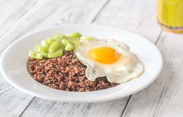 Portion of red quinoa with fried egg and celery