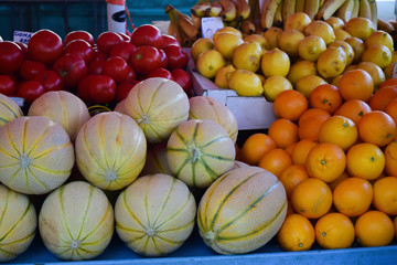 Fruit Stand With Cantalope, Tomatoes, Lemons, Oranges And Bananas
