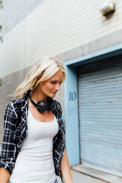 USA, New York City, Brooklyn, young woman with headphones in the city on the go