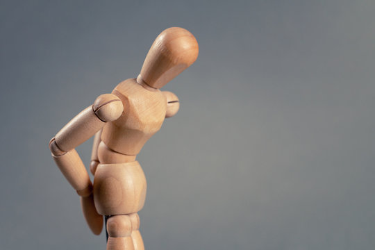 Wooden man with back pain or hemorrhoids. Copy space.